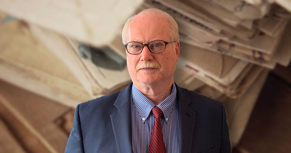 David O’Neill standing in front of old files and documents that could lead to insurance archeology success